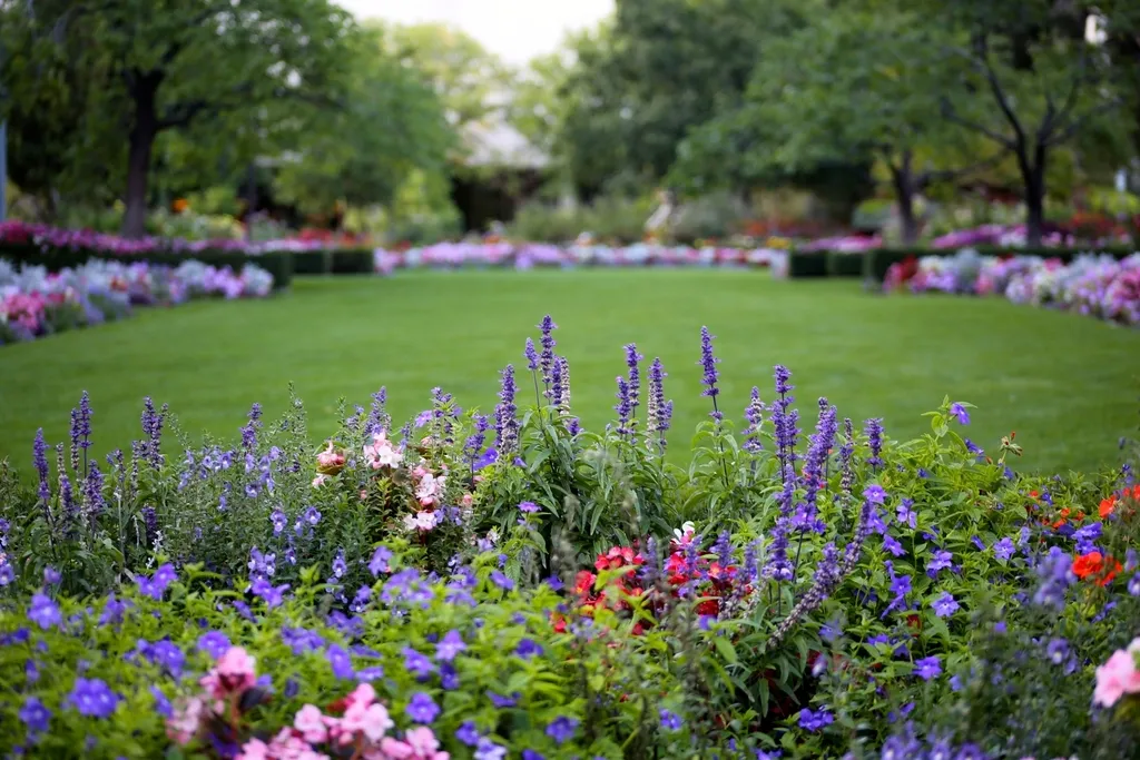 Colorful flower beds surrounding an oval green lawn