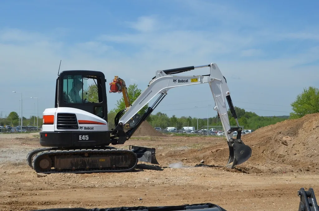 Compact excavator working on a graded dirt site