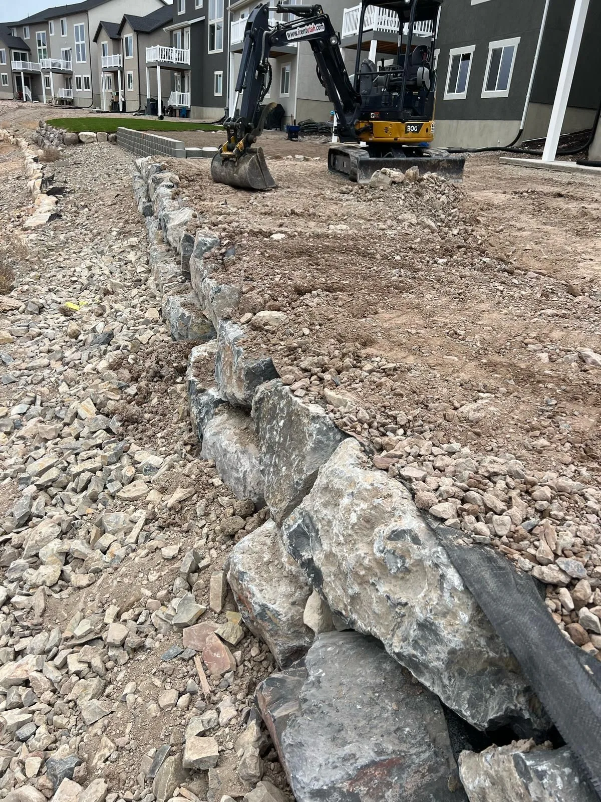 Muro de rocas y tierra nivelada durante la preparación del terreno