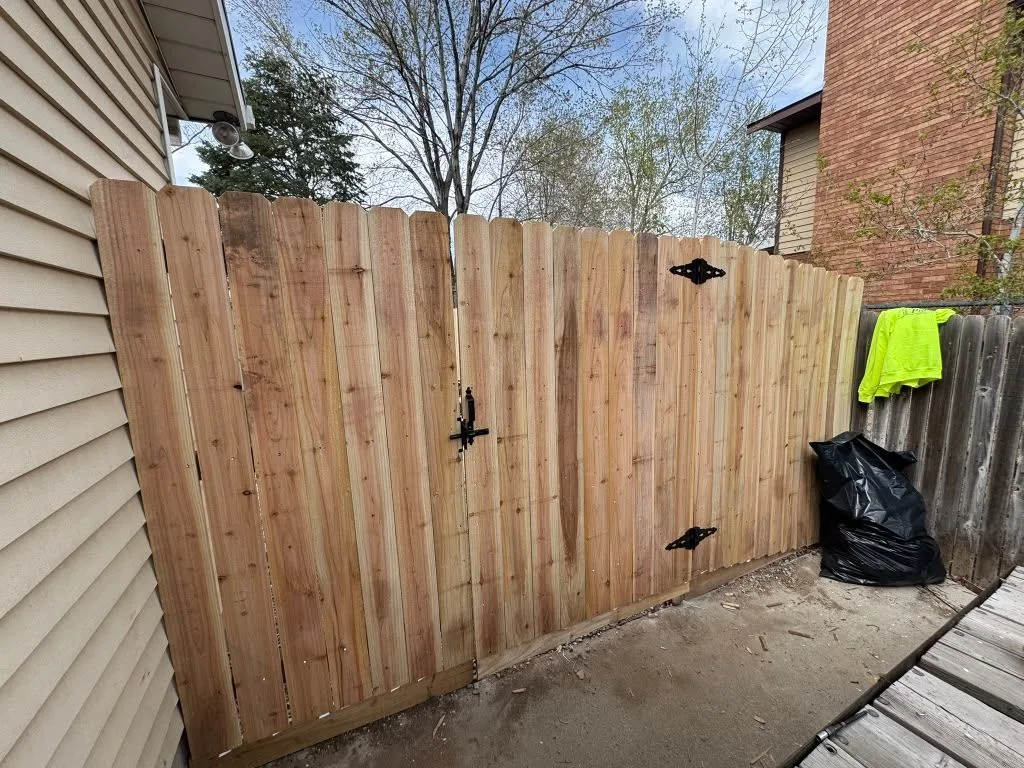 New wood privacy fence with a double gate and black hardware