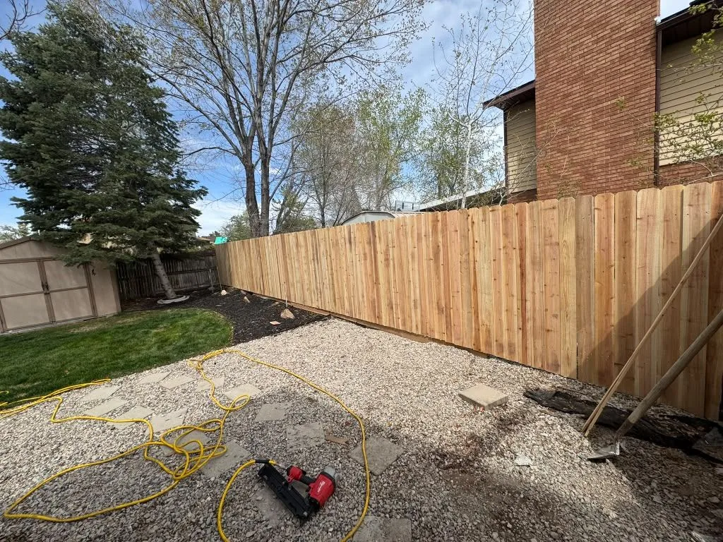 Wood privacy fence installation in progress in a backyard
